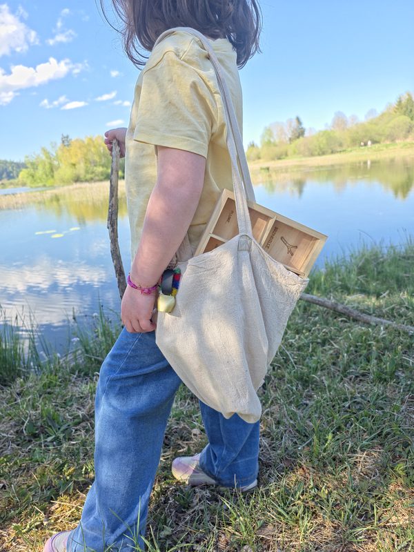 Enfant explorateur avec sa boîte au bord du lac